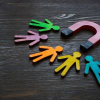 image representing employee retention - cutout people being attracted by a magnet