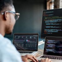 Young Black male programmer writing code