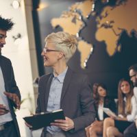 people in office with world map in the background