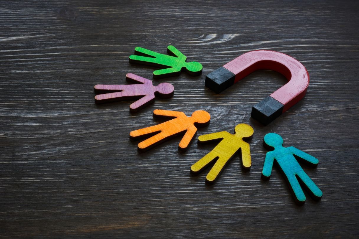 image representing employee retention - cutout people being attracted by a magnet