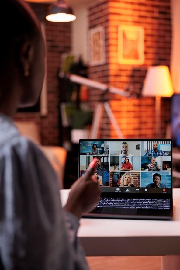 Businesswoman chatting with remote team online using laptop