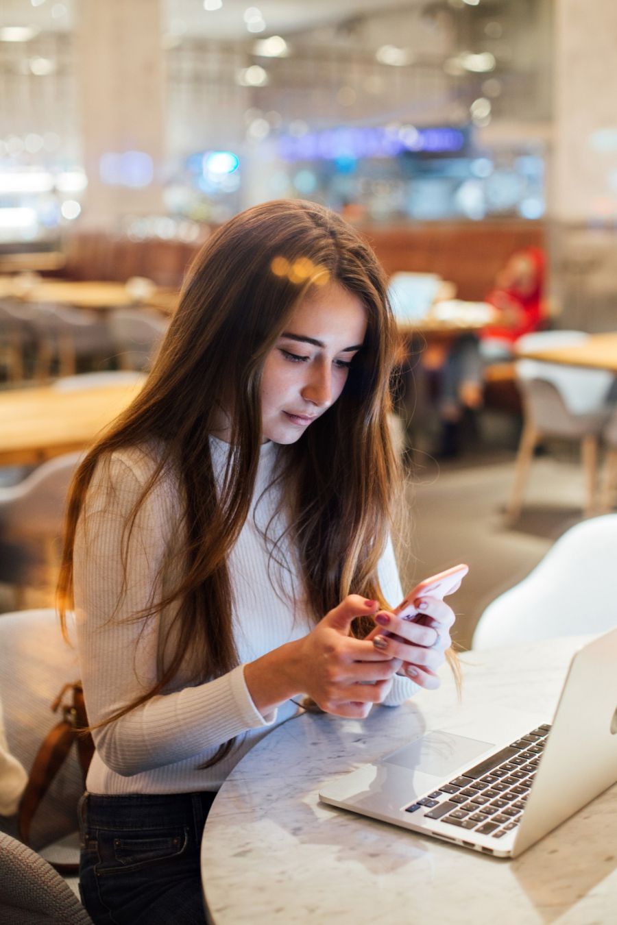 Girl on Phone and Laptop in Cafe