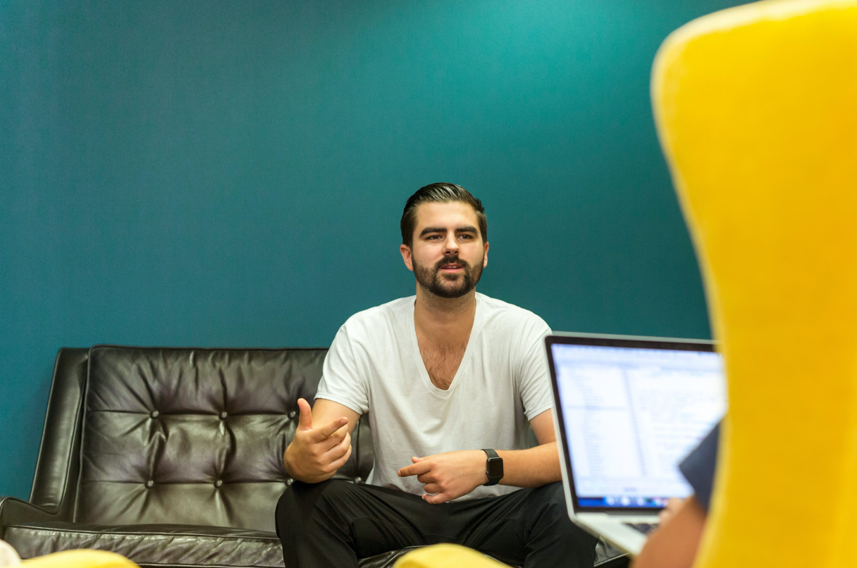 Man sat down while leading a sales meeting
